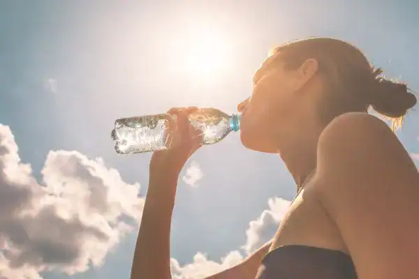 Hydration: The Secret Ingredient for a Toned Stomach and Enhanced Fitness 3 Image of woman drinking water to hydrate Chester after run.
